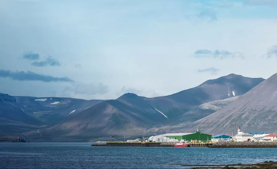 Small Town on Waterfront with Mountain Range and Sky Backdrop